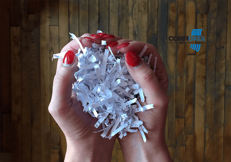 shredded paper in a person's hand making the shape of a heart