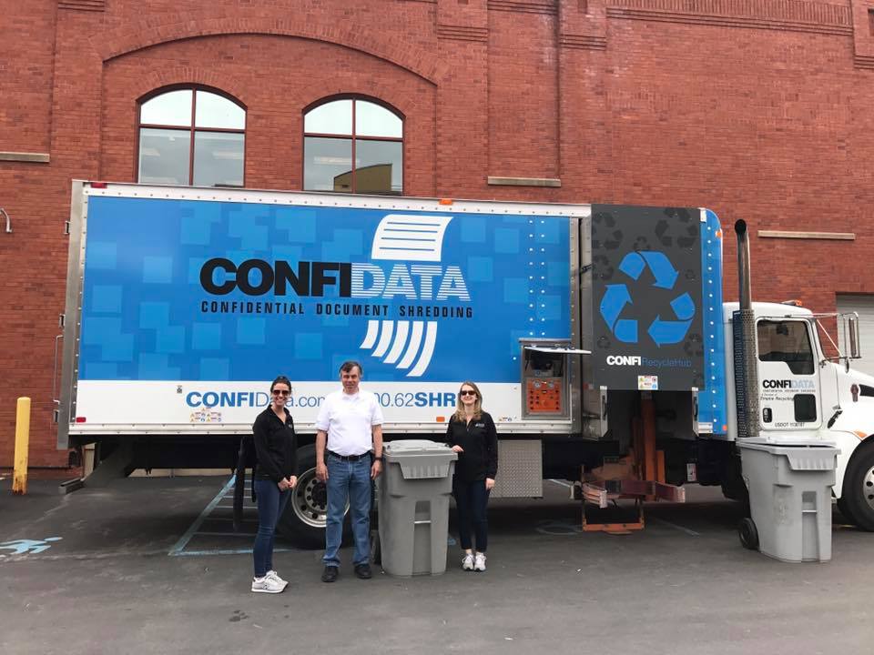 Confidata team posing by their mobile shredding truck at a Saratoga shred event